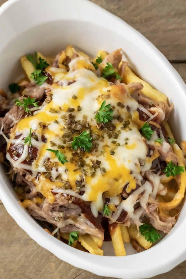 a close up top down view of Cheesy BBQ Pulled Pork Fries in a baking dish