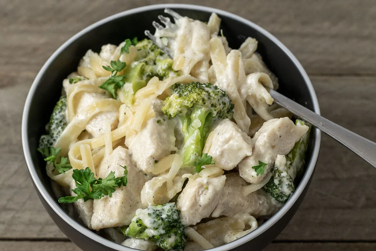 a bowl filled with Chicken Fettuccine Alfredo with Broccoli.