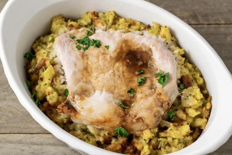 Baked Pork Chops and Stuffing in a casserole dish.