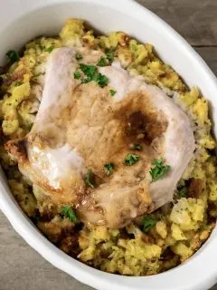 Baked Pork Chops and Stuffing in an individual white baking dish.