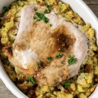 Baked Pork Chops and Stuffing in an individual white baking dish.