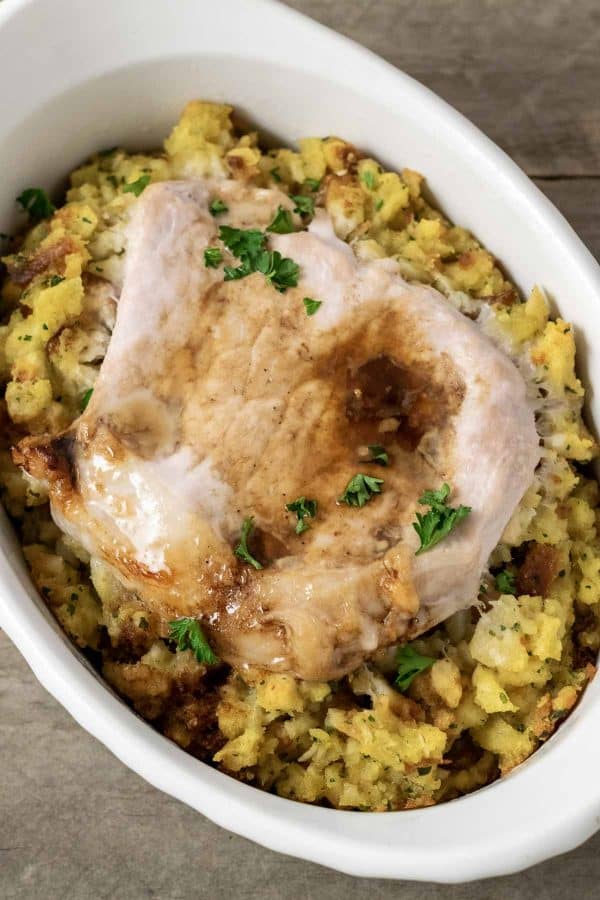 Baked Pork Chops and Stuffing in an individual white baking dish.