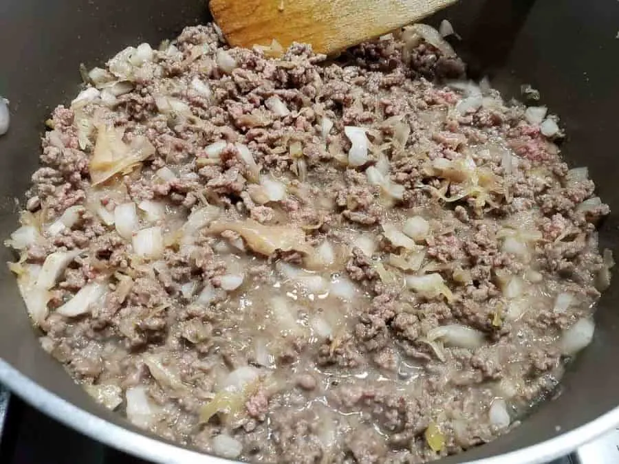 ground beef and onion cooking in a frying pan