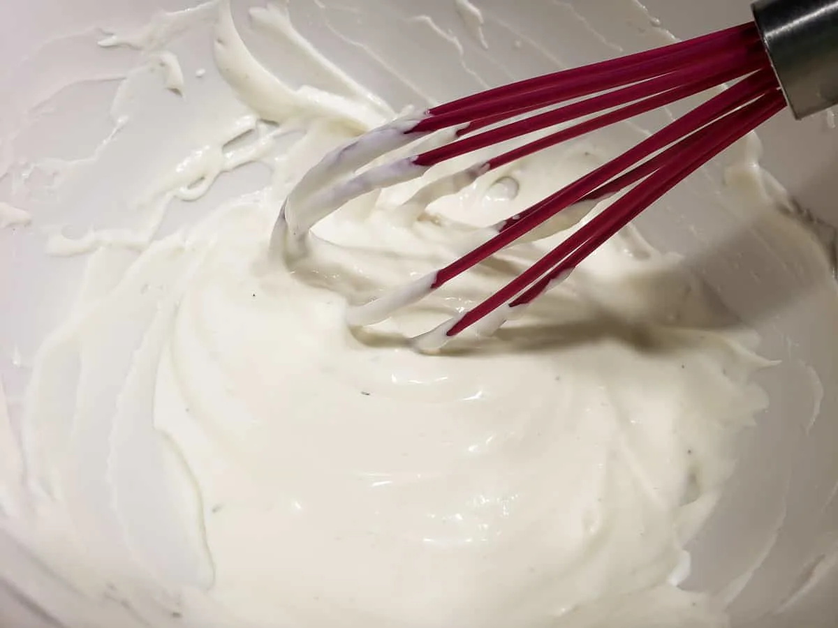 sour cream, mayo, and ranch salad dressing whisked in a bowl