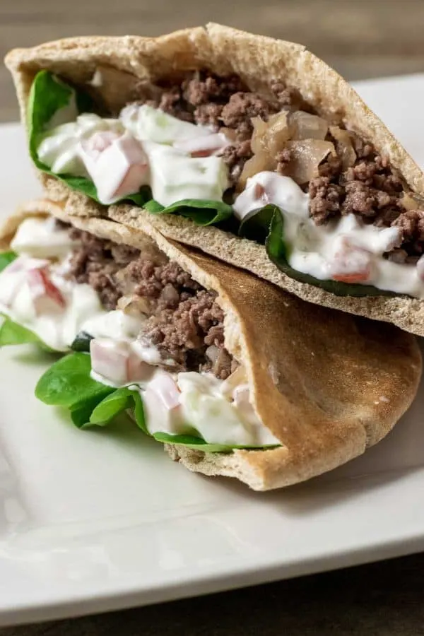 two half Gyro Style Pita Bread Sandwiches on a platter