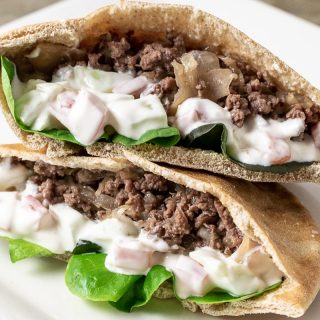 two half Gyro Style Pita Bread Sandwiches on a white plate