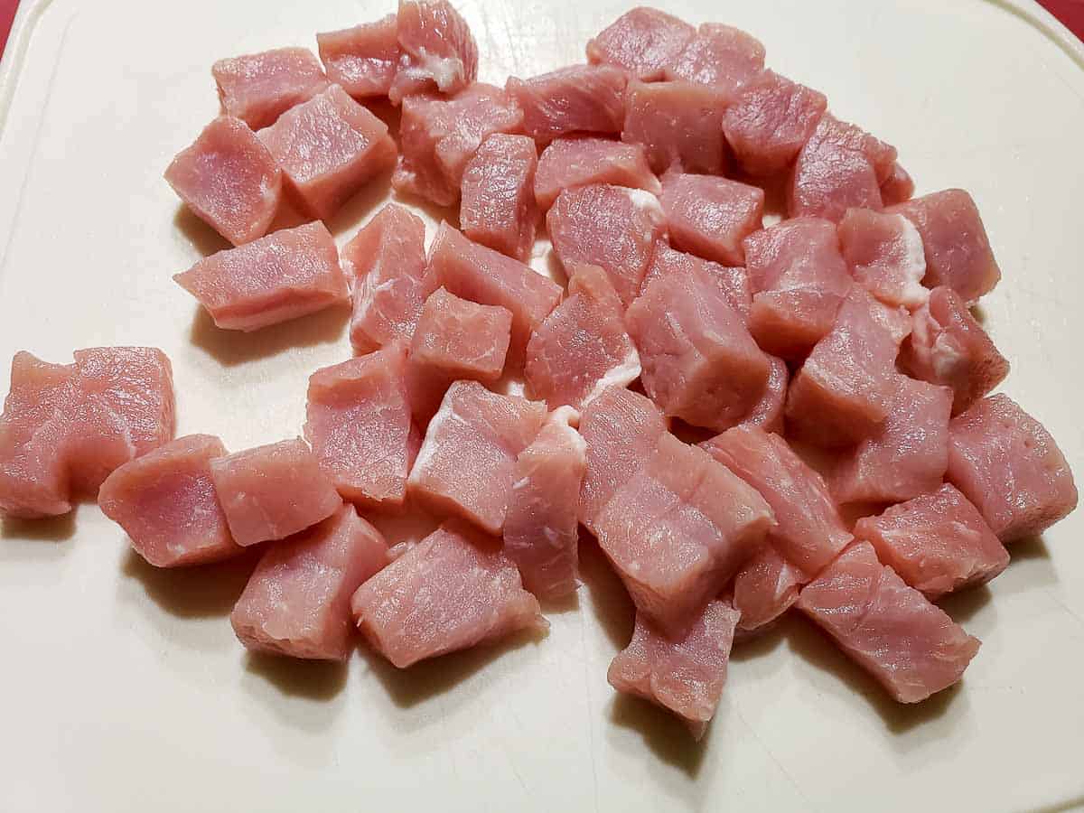 pork cut into cubes on a cuttiing board
