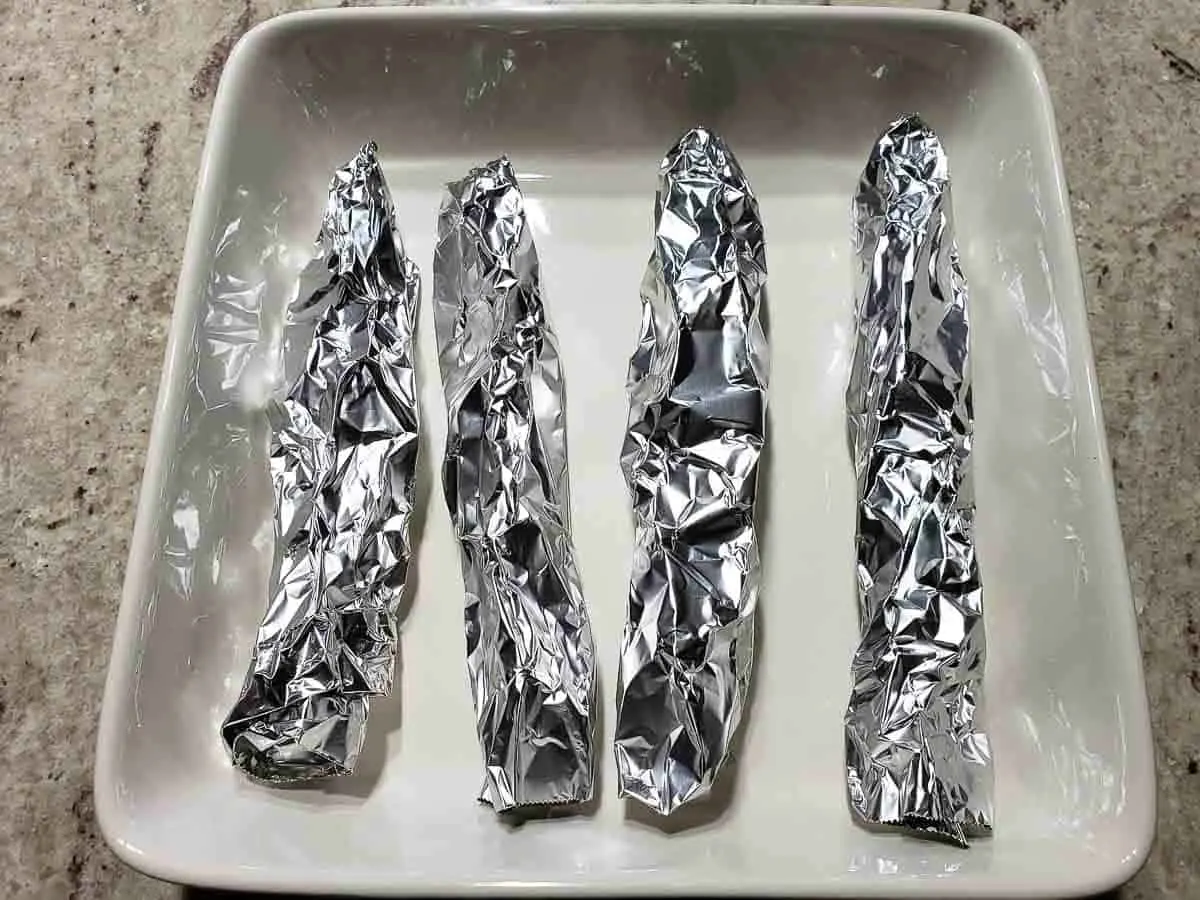 4 pieces of rolled up tinfoil in a baking dish