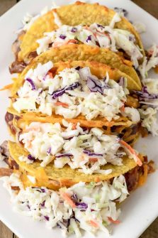 a plate filled with 5 Smoky BBQ Pulled Pork Tacos with Slaw