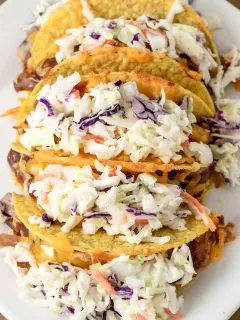 a plate filled with 5 Smoky BBQ Pulled Pork Tacos with Slaw