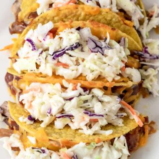 a plate filled with 5 Smoky BBQ Pulled Pork Tacos with Slaw