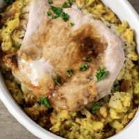 Baked Pork Chops and Stuffing in an individual white baking dish.