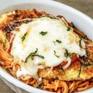 Chicken parmesan and spaghetti in a white dish