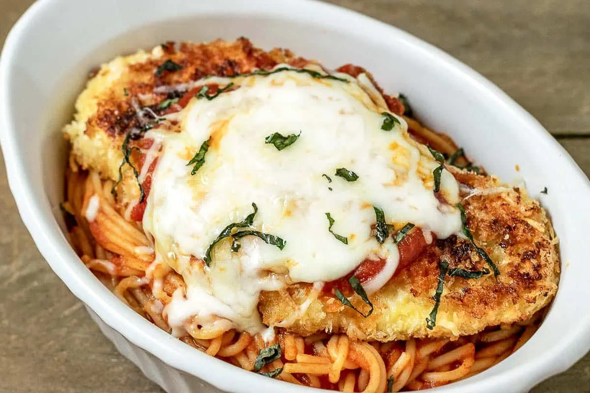Chicken parmesan and spaghetti in a white dish