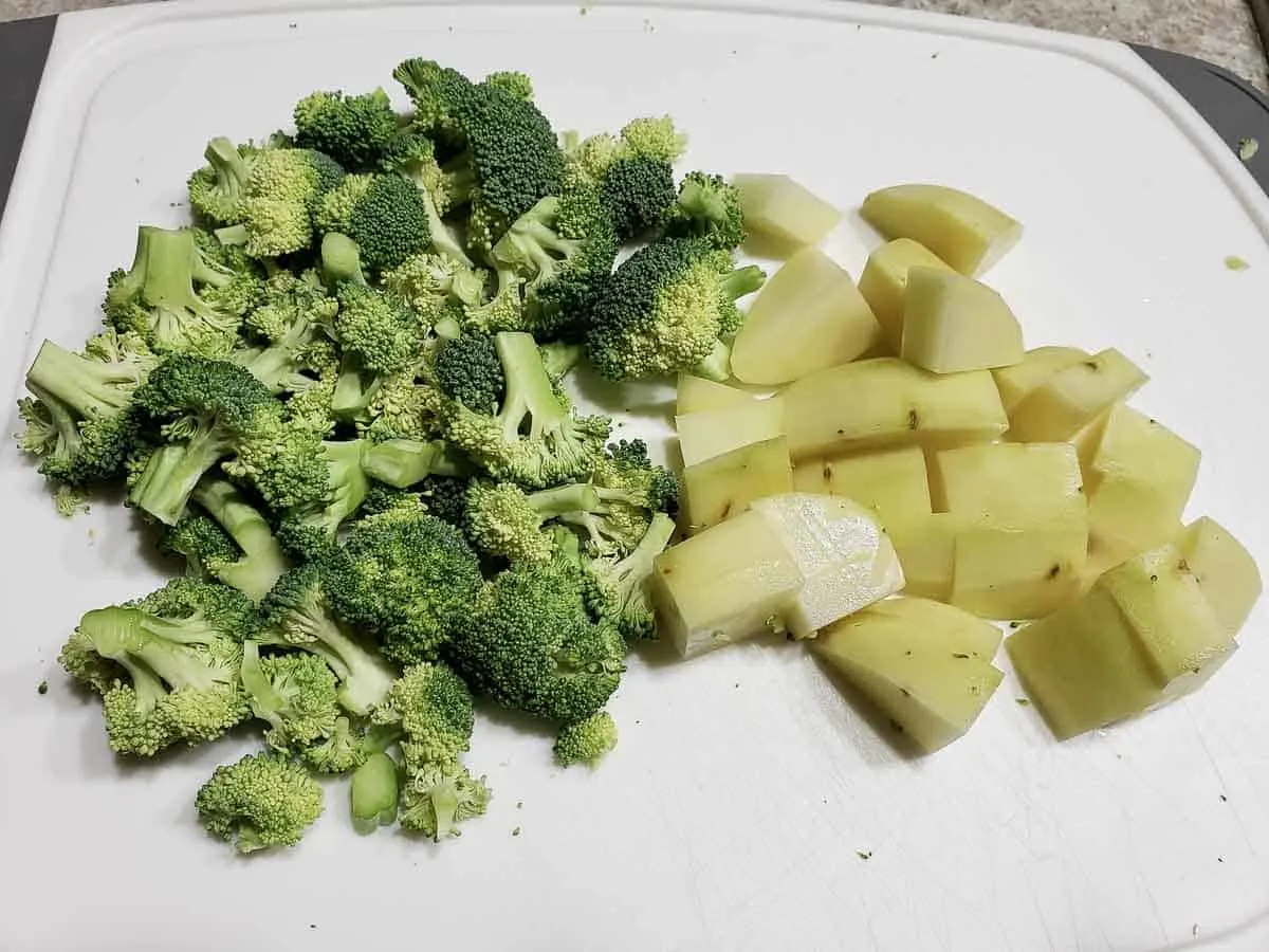 chopped potatoes and broccoli on a cutting board.