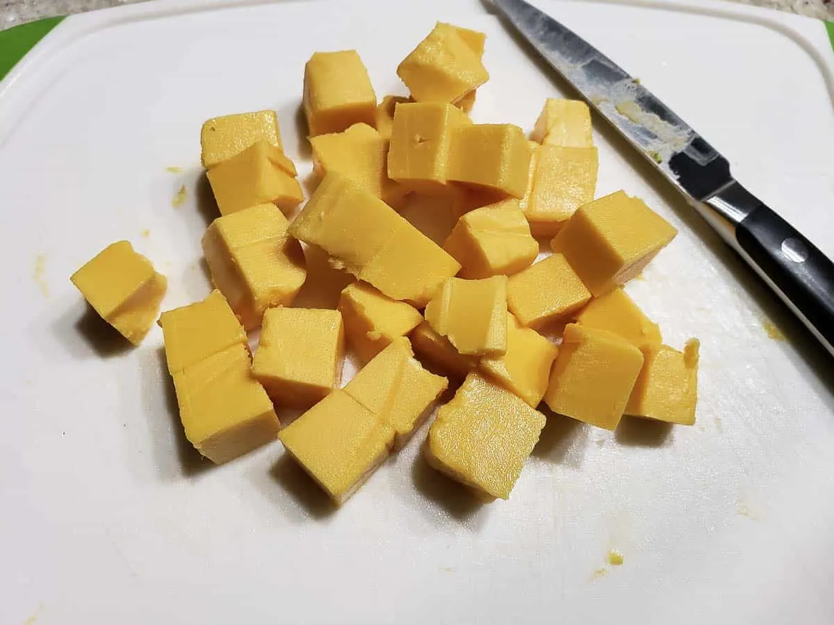 cubed velveeta cheese on a cutting board.