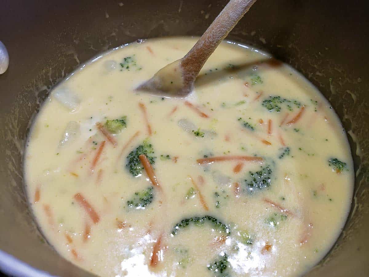 cheese vegetable soup cooking in a pan.