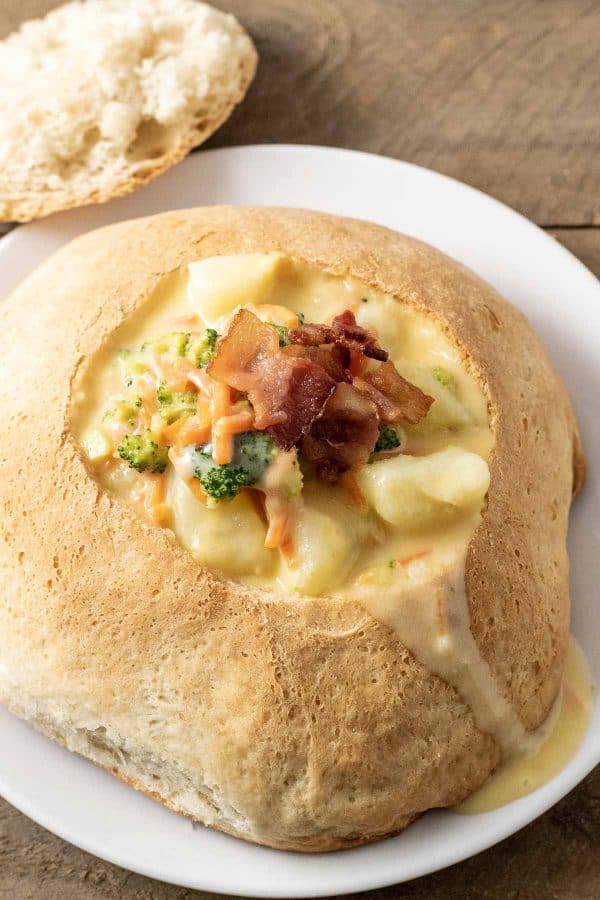 a homemade bread bowl filled with cheesy vegetable soup.
