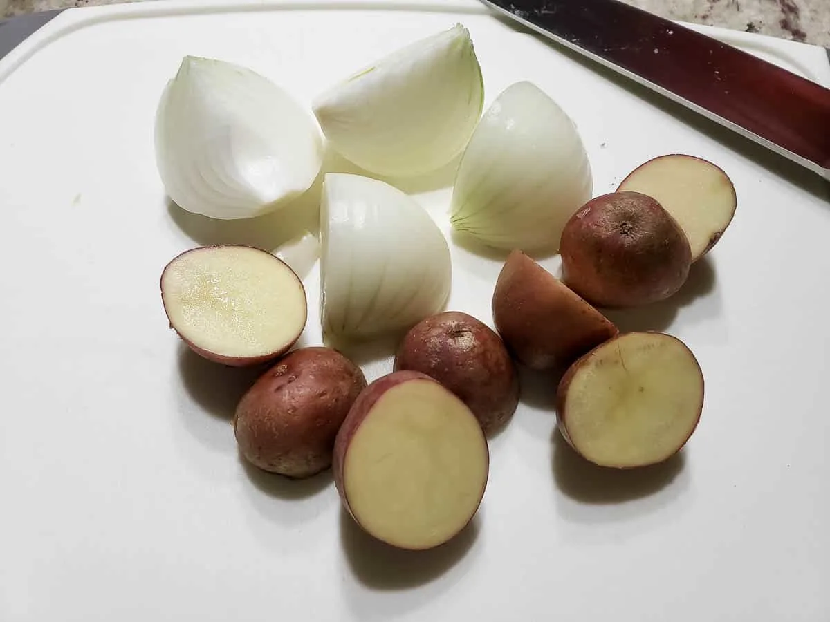 a quartered onion and red potatoes cut in half.