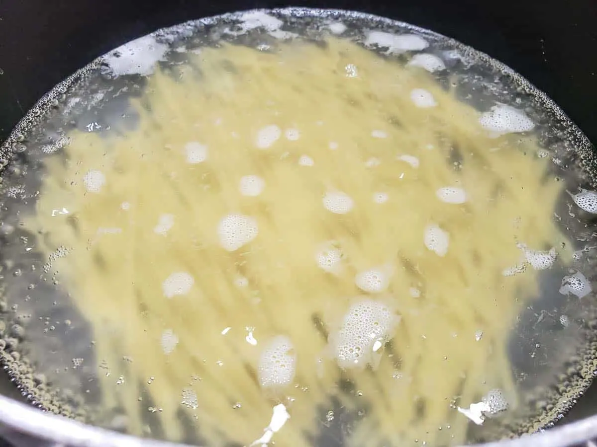 linguine pasta noodles cooking in boiling water.