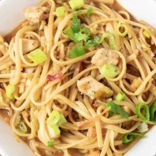 Chicken and Noodles in Thai Peanut Sauce in a square white bowl