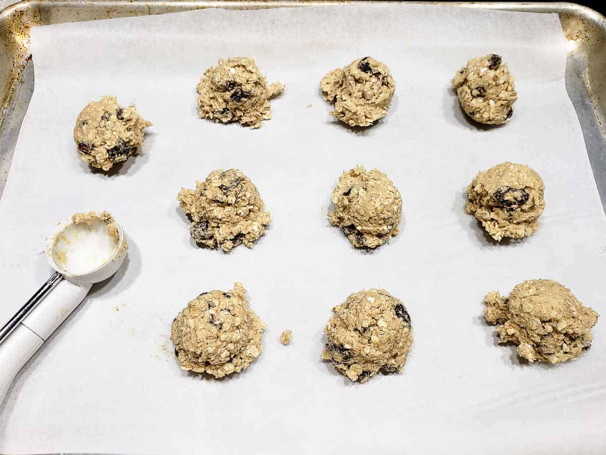 10 balls of oatmeal raisin cookie dough scooped onto a baking sheet.