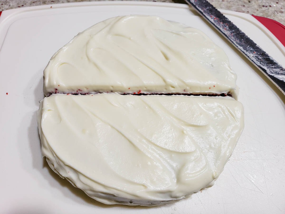 a round frosted cake cut in half from one edge to the other making two half circles