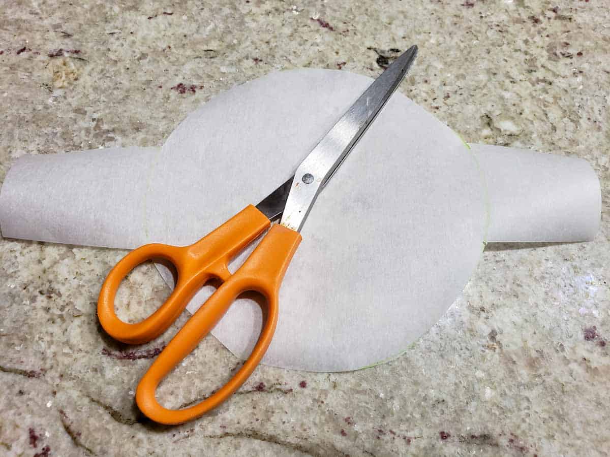 a circle parchment paper with tabs and a pair of scissors