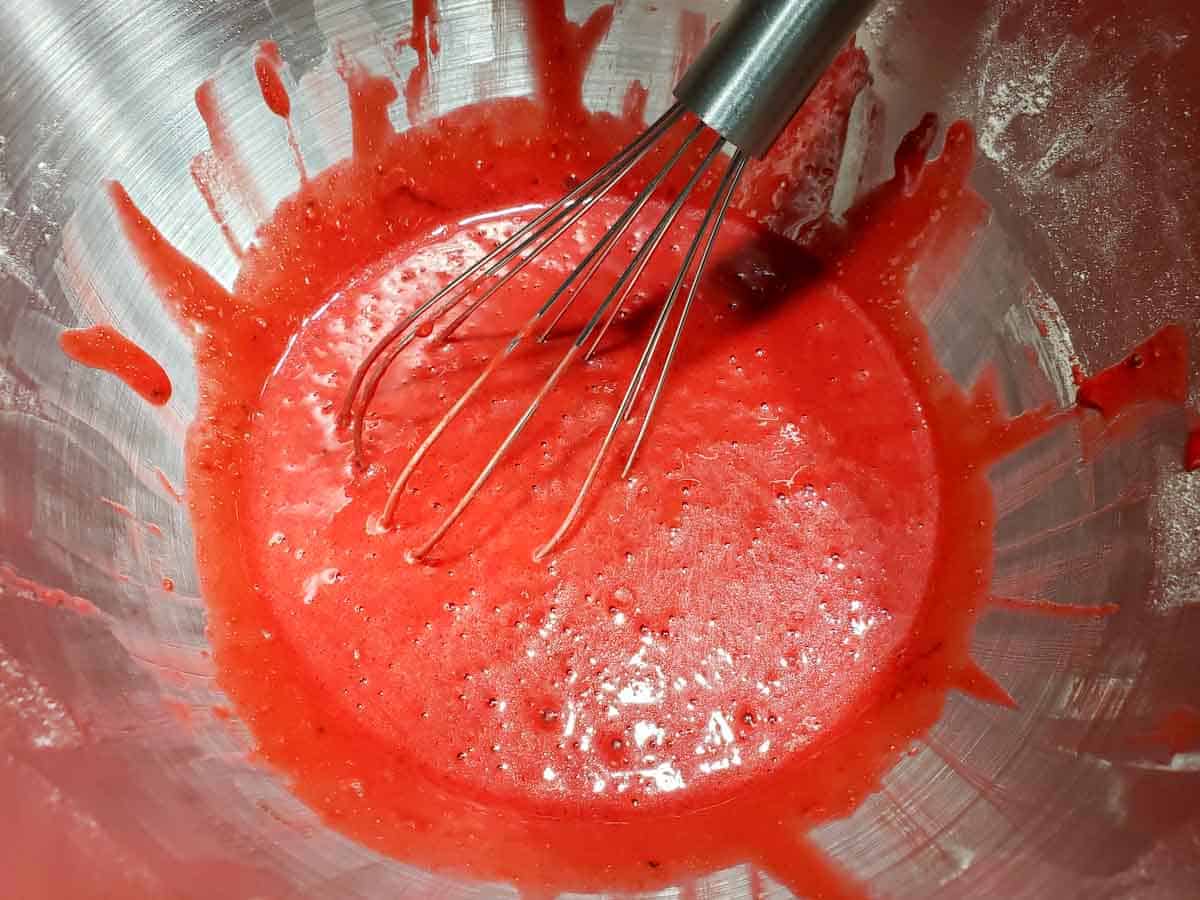 red velvet cake batter in a bowl with a whisk