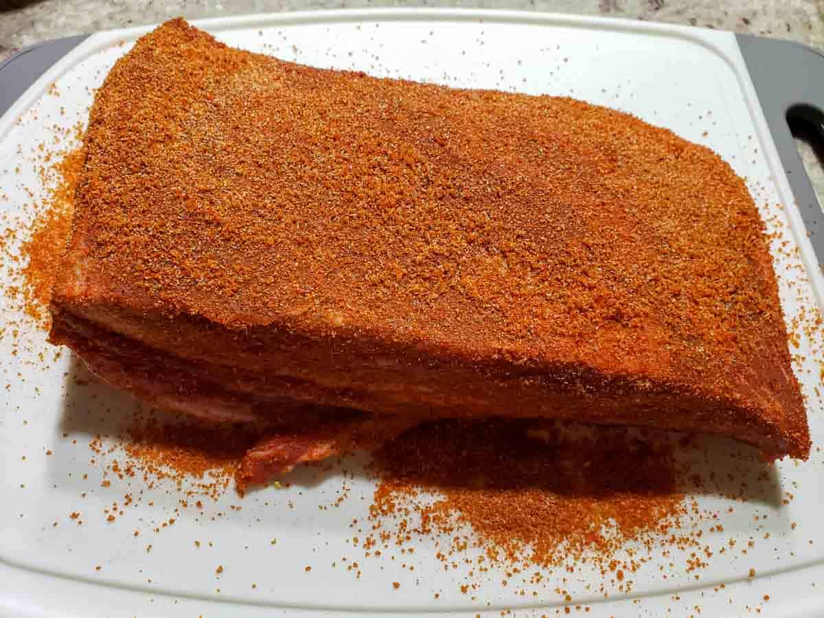 a raw beef brisket covered in dry rub seasonings