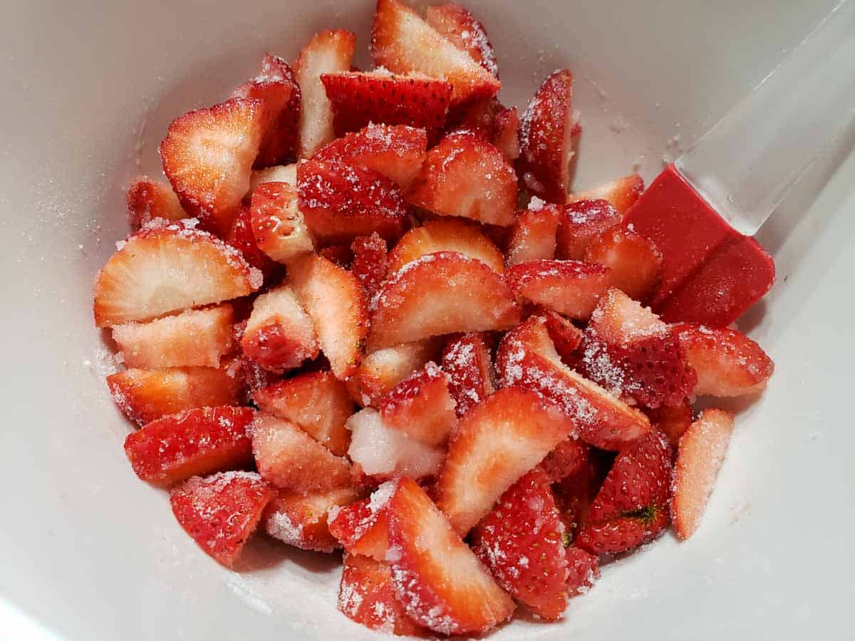 sliced strawberries and sugar mixed in a bowl