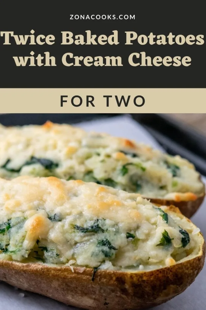two twice baked potatoes with cream cheese and spinach on a baking sheet.