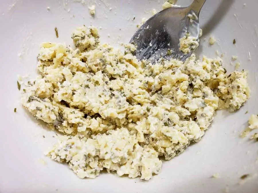 a bowl filled wit parmesan cheese and mayo mixture
