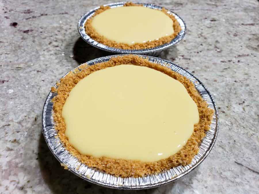 two small graham crusts filled with creamy yellow key lime pie filling.