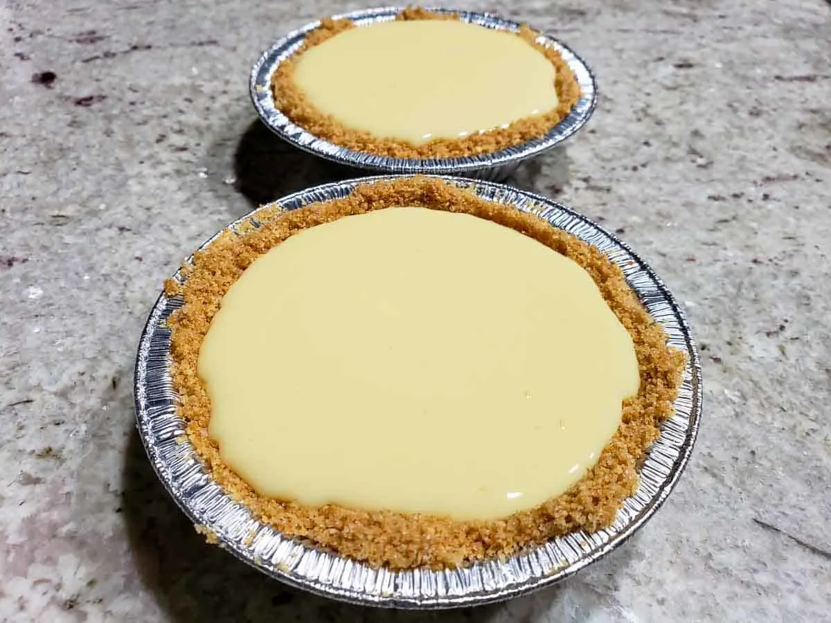 two small graham crusts filled with creamy yellow key lime pie filling