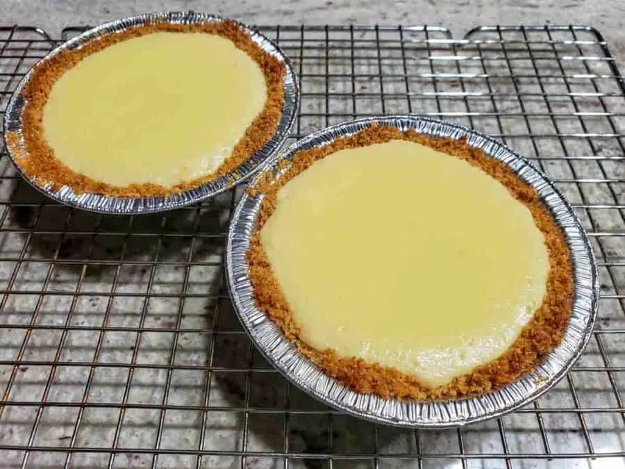 two mini key lime pies cooling on a wire rack.