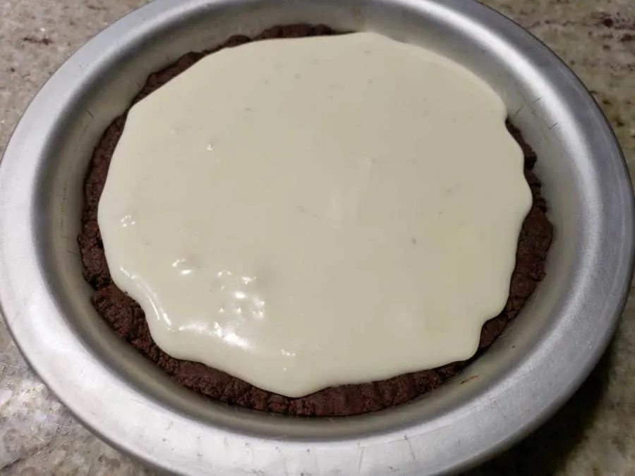 a small pie pan filled with chocolate crust and cream cheese filling.
