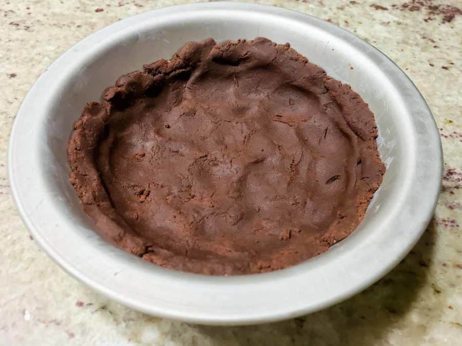 a small pie pan filled with chocolate crust pressed into it.
