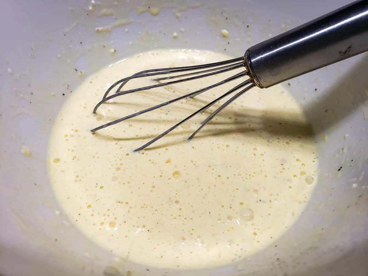 eggs, heavy cream, parmesan cheese, garlic salt, pepper, mustard, and onion powder whisked in a bowl