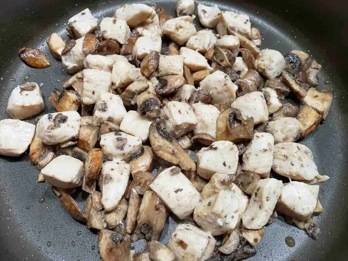 diced chicken and mushrooms cooking in a pan