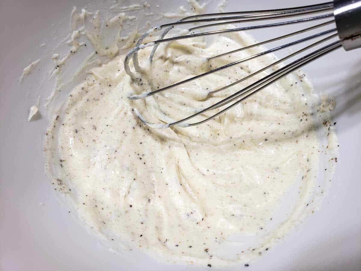 white creamy mayo mixture in a bowl with a whisk
