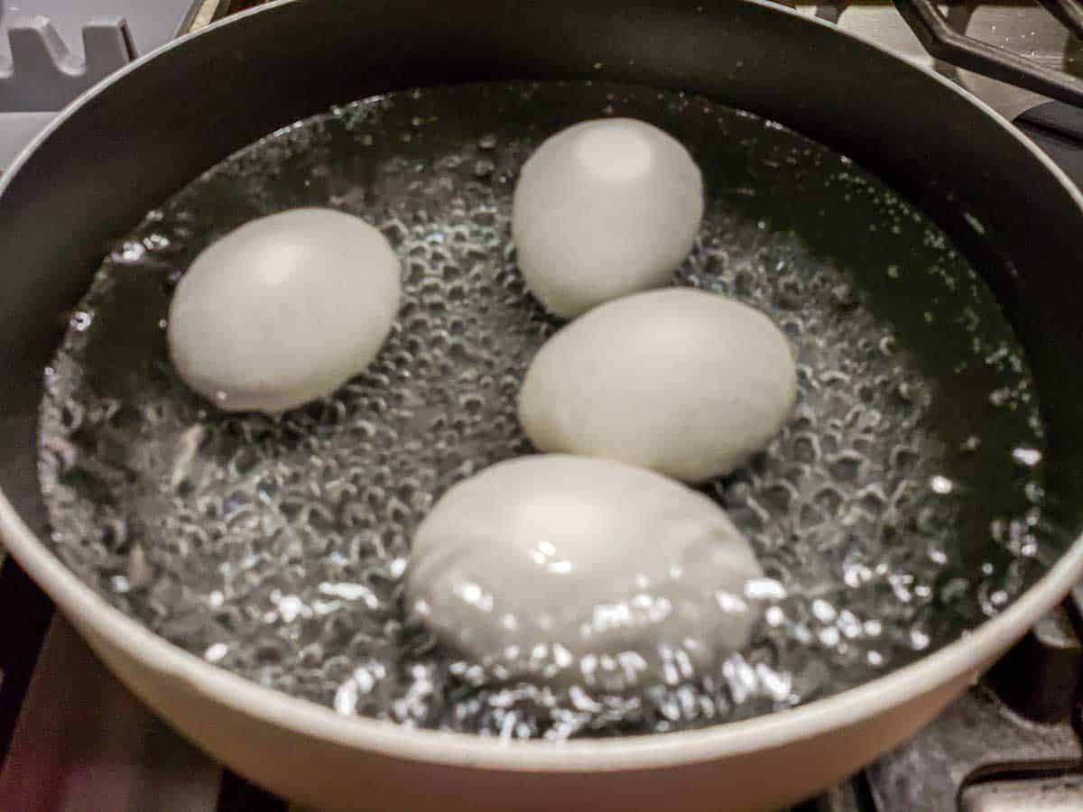 4 jumbo eggs boiling in a saucepan