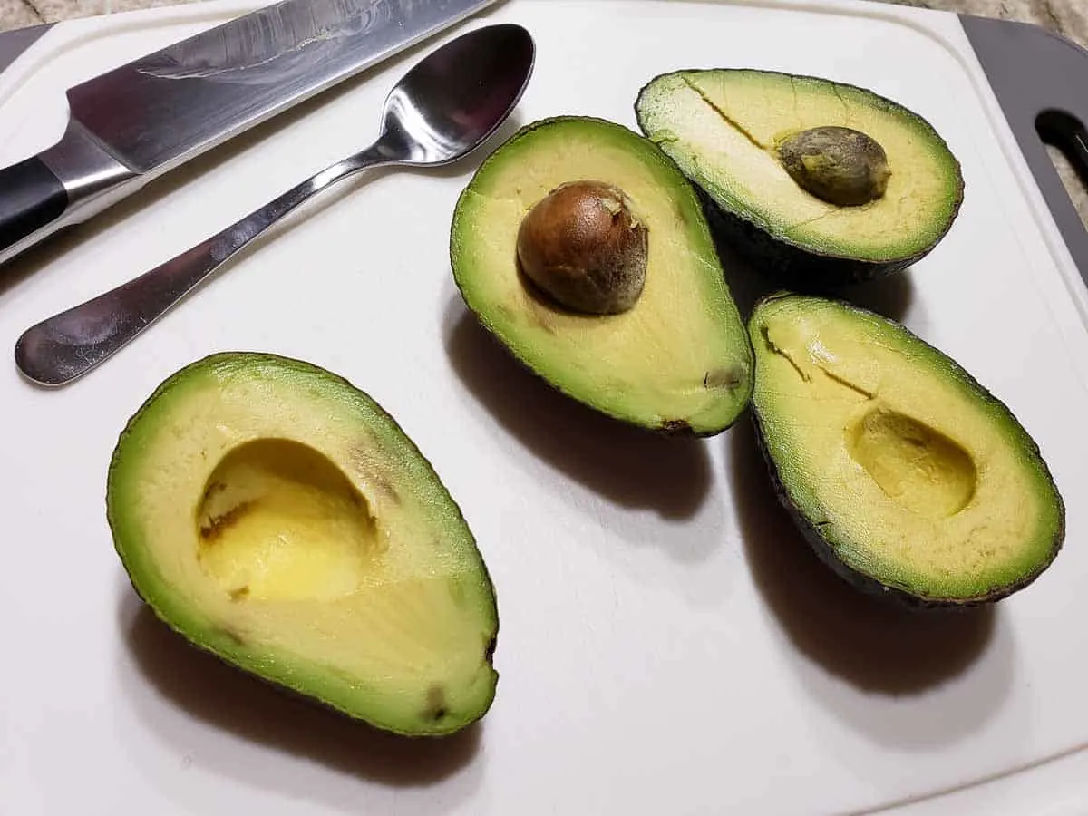 4 avocado halves on a cutting board