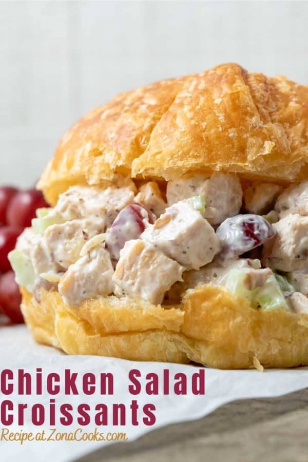 Chicken Salad Croissant with boneless chicken, grapes, almonds, and celery coated in a mayo dressing piled in large buttery croissant rolls and text reading chicken salad croissants recipe at zonacooks.com.