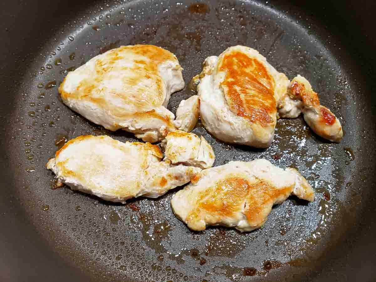 a frying pan filled with golden brown boneless chicken pieces.