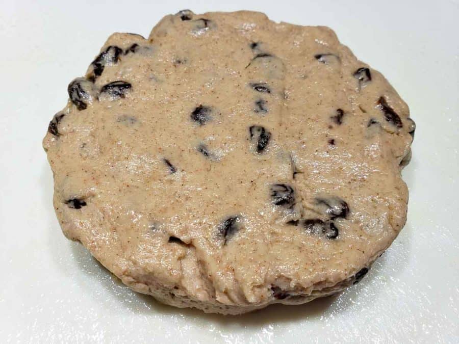 raisin scone dough formed into a 1 inch thick circle
