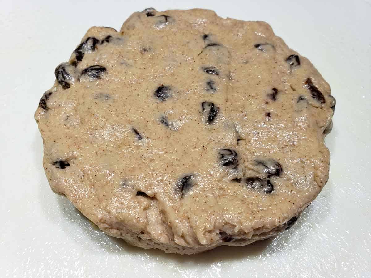 raisin scone dough formed into a 1 inch thick circle