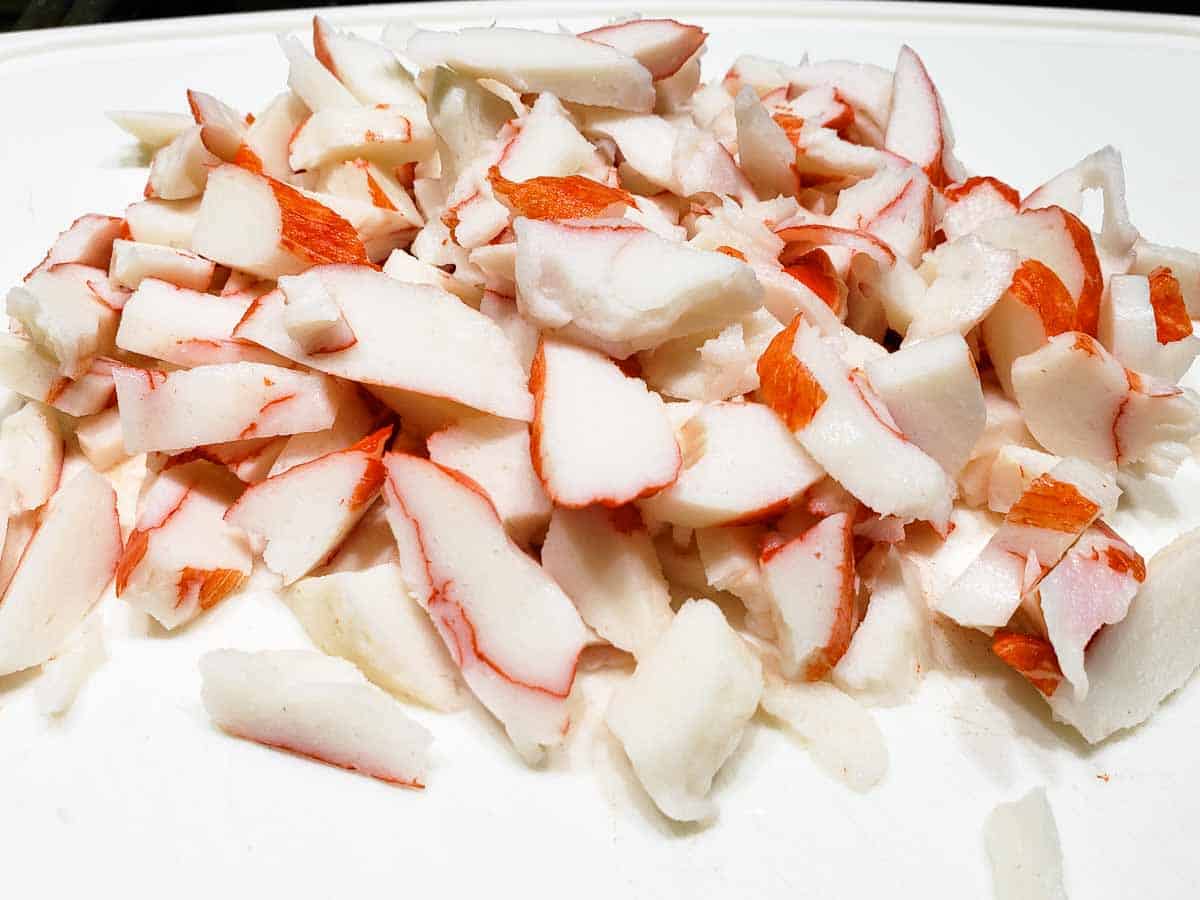 imitation crab meat chopped on a cutting board.