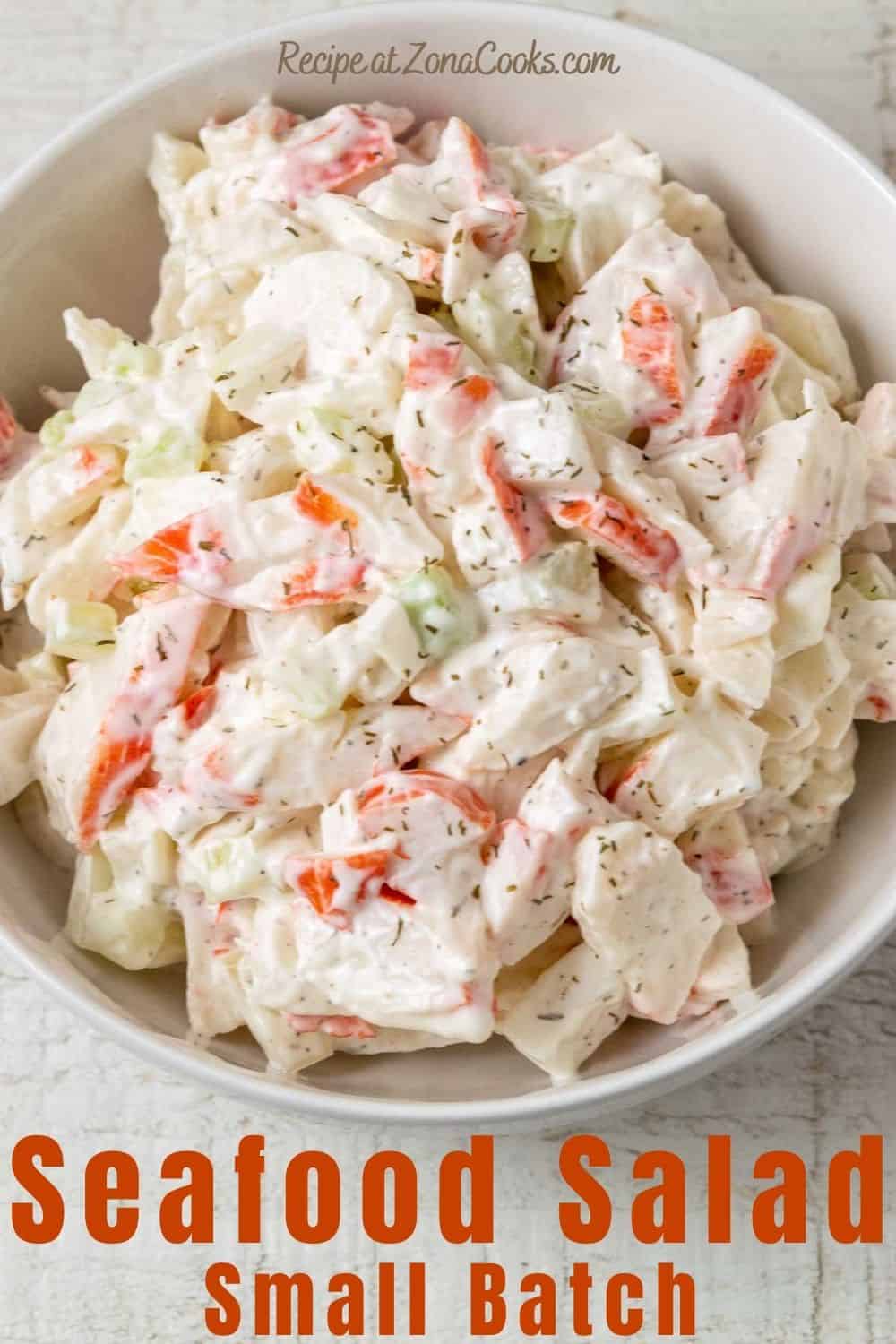 a bowl of seafood salad with chopped imitation crab meat combined with onion and celery in a creamy mayonnaise dressing and text reading recipe at zonacooks.com seafood salad small batch.