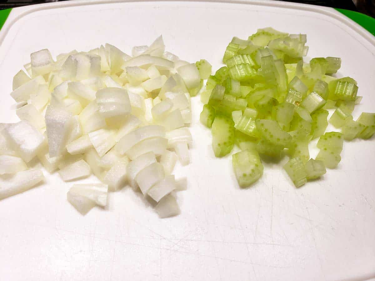 diced onions and celery on a cutting board.